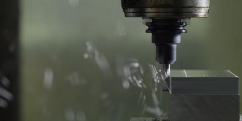 Close up image of a manufacturing tool shaving metal. 