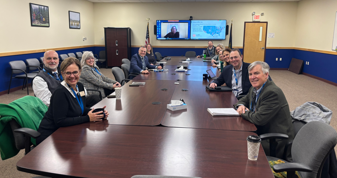 A group of people sitting at a large table in a conference room.