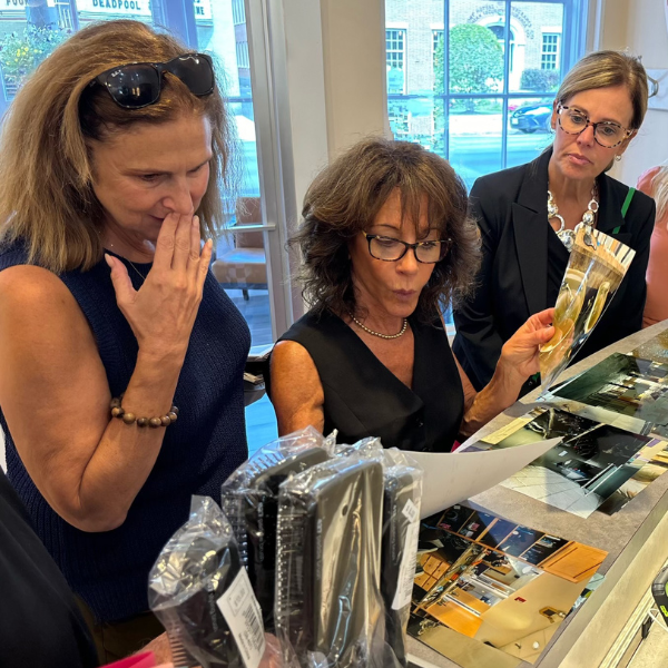 Three people stand at a counter looking at printed out images of a flooded building.