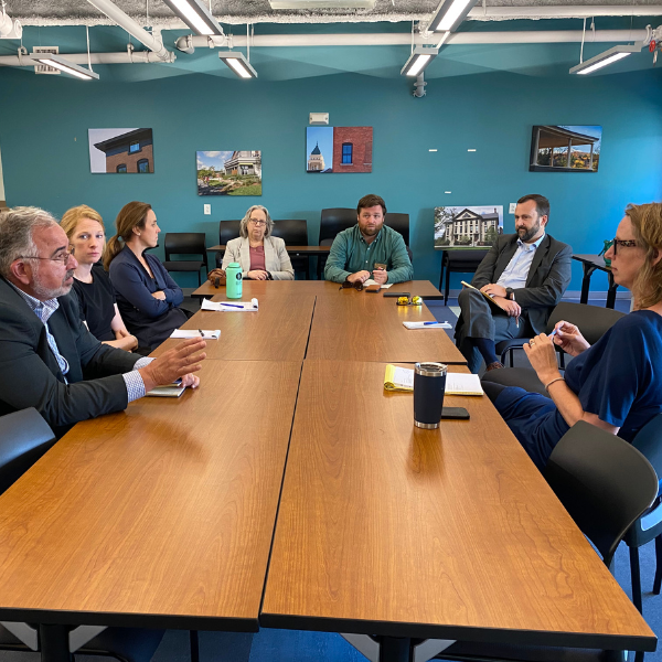 Seven people seated around a large table for a business meeting.