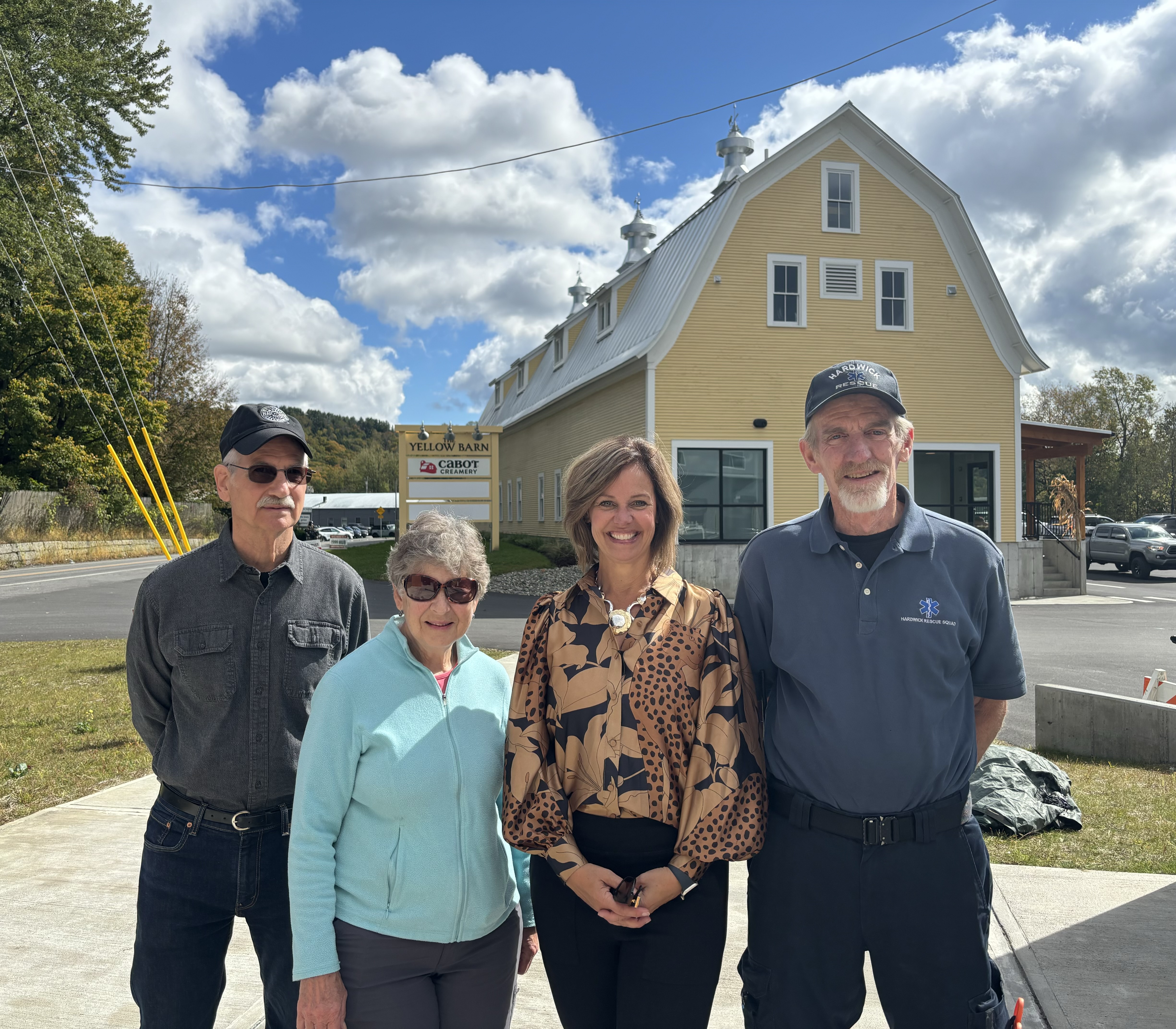 Group of four people standing in front of a barn.