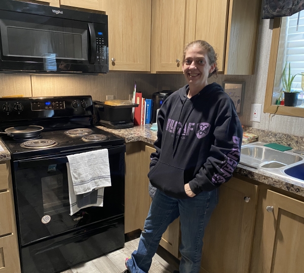 Kendra standing in her kitchen