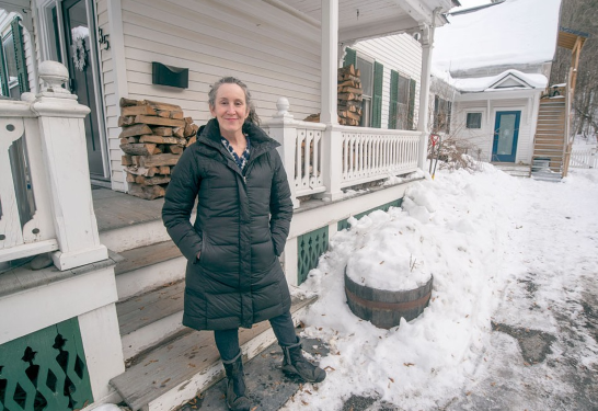 Marni Leikin in front of her Montpelier home. She built a one-bedroom ADU above the carriage barn in her backyard (see background).