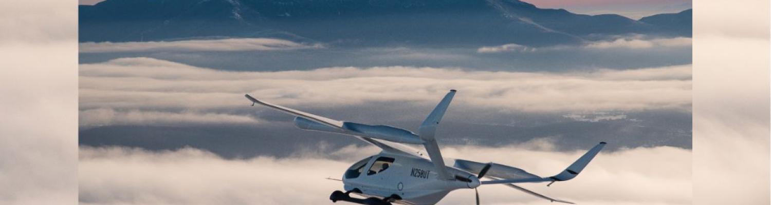 Aircraft flying with mountains in the background.